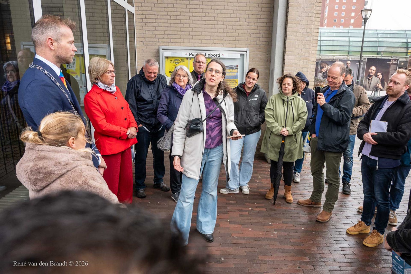 Inwoners en vertegenwoordigers komen samen bij het gemeentehuis van Houten rond het hijsen van de regenboogvlag